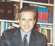 A man in a suit and tie sitting at a desk.