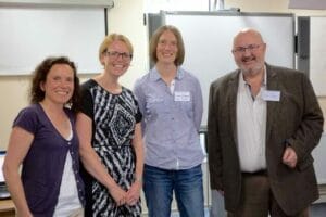 A group of people posing for a photo in a classroom.