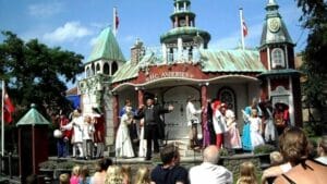 A group of people on stage in front of a castle.