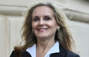 A woman in a business suit smiling.