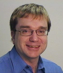 A man wearing glasses and a blue shirt.