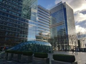 An office building with a glass roof in front of it.