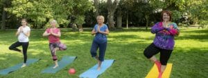 A group of women doing yoga in a park.