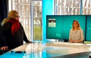 A woman standing in front of a television.