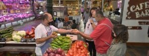 A man shakes hands with a woman at a market.