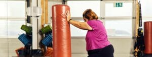 A woman doing a punching bag in a gym.