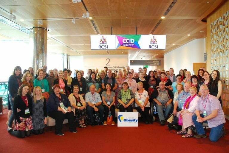 A group of people posing for a photo in a conference room.