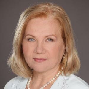 A portrait of a woman with blonde hair and pearls.