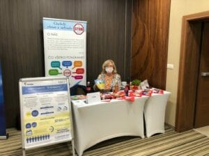 A woman standing in front of a table with a poster.