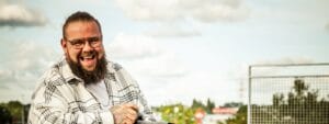 A man with a beard and glasses on a motorcycle.