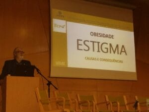 A man standing at a podium in front of a screen.