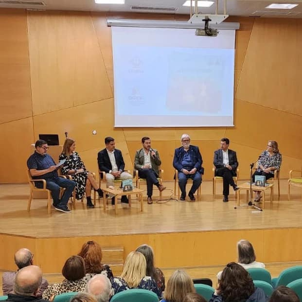 A group of people sitting on chairs in front of a screen.