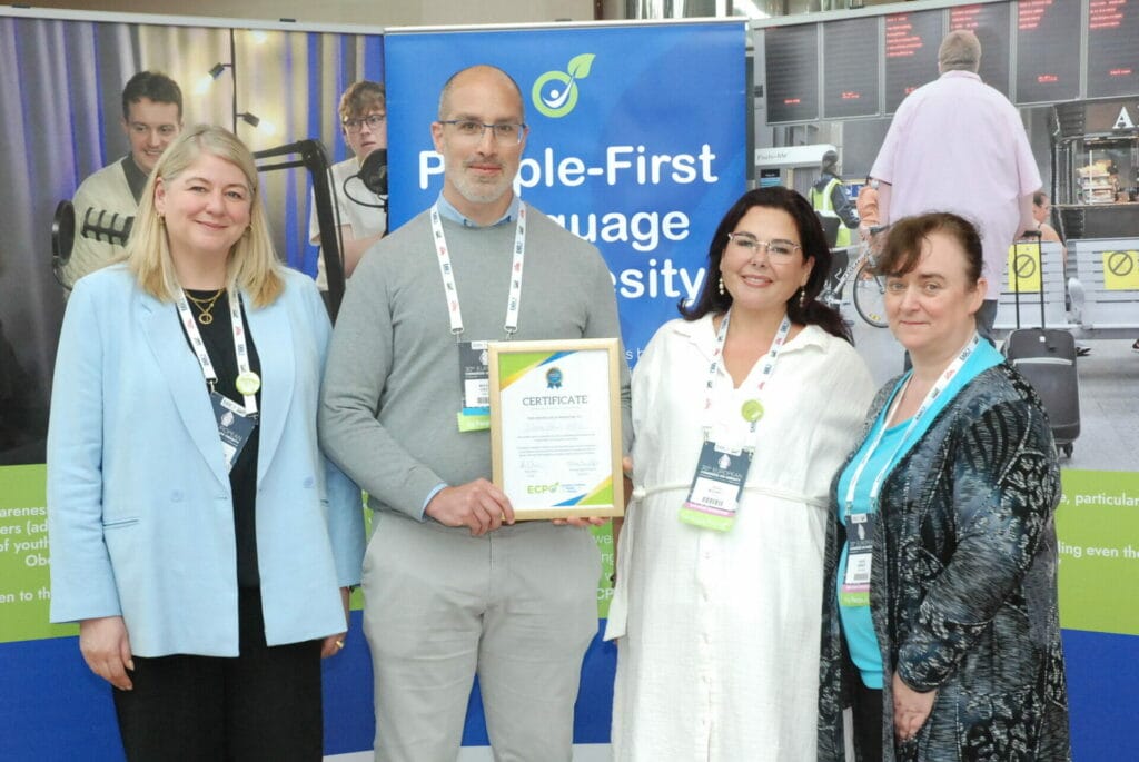 A group of people posing for a picture in front of a banner.