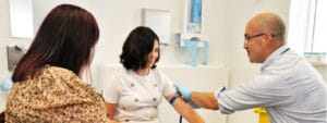 A woman is getting a blood test from a doctor.