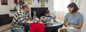 A family sits at a table and eats a meal.