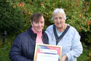Two women standing next to each other holding a certificate.