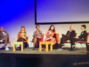 A group of people sitting on chairs on a stage.