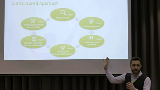 A man giving a presentation in front of a screen.