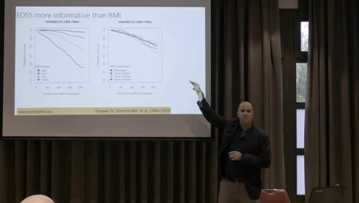 A man giving a presentation in front of a screen.
