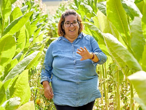 A woman standing in a field posing for a photo.