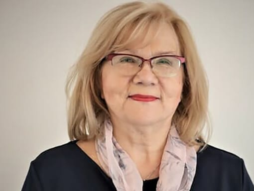 A woman wearing glasses and a scarf.