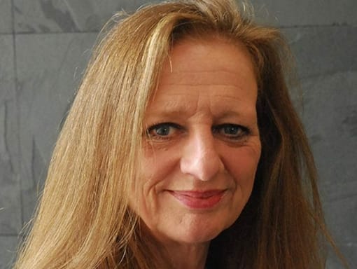 A woman with long hair smiling.