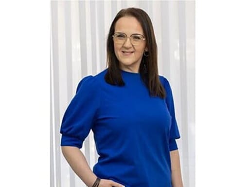 A woman in a blue shirt posing for a photo.