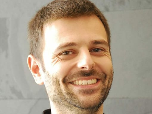 A smiling man wearing a black shirt.