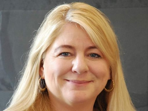 A woman with long blonde hair smiling for the camera.