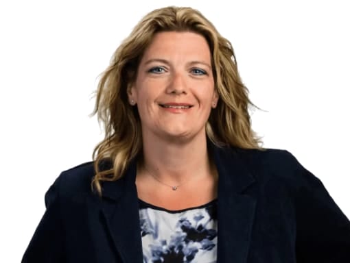 Portrait of a smiling caucasian woman in a blue blazer and floral top against a white background.