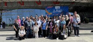 A group of people posing for a photo outside a convention center with a banner reading "32nd European Congress on Obesity.